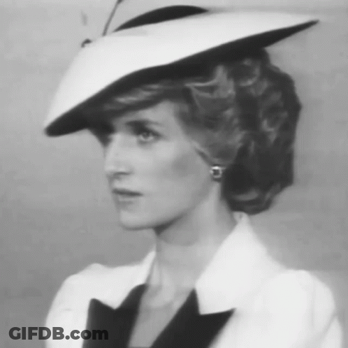 A Black And White Photo Of A Woman Wearing A White Hat And Earrings GIF