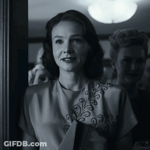 A Black And White Photo Of A Woman Wearing A White Top GIF