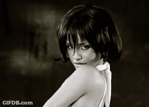 A Black And White Photo Of A Woman Wearing A White Top GIF