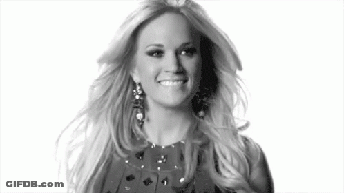 A Black And White Photo Of A Woman Wearing Earrings And A Dress . GIF