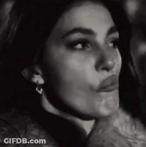 A Black And White Photo Of A Woman Wearing Earrings And Making A Funny Face . GIF