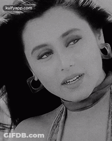 A Black And White Photo Of A Woman Wearing Hoop Earrings And A Choker . GIF