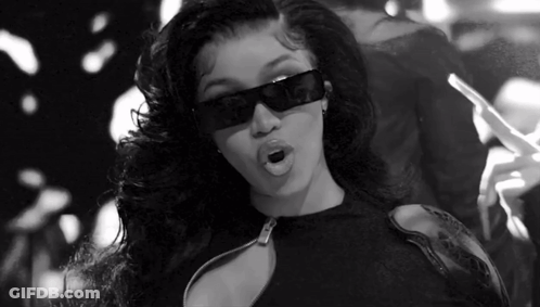 A Black And White Photo Of A Woman Wearing Sunglasses And Holding A Cigarette . GIF