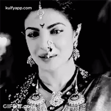 A Black And White Photo Of A Woman With A Nose Ring On Her Nose . GIF