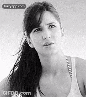A Black And White Photo Of A Woman With A Ponytail Making A Funny Face . GIF