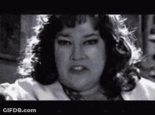 A Black And White Photo Of A Woman With A Very Serious Look On Her Face . GIF