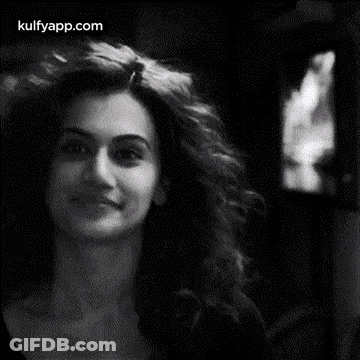 A Black And White Photo Of A Woman With Curly Hair . GIF