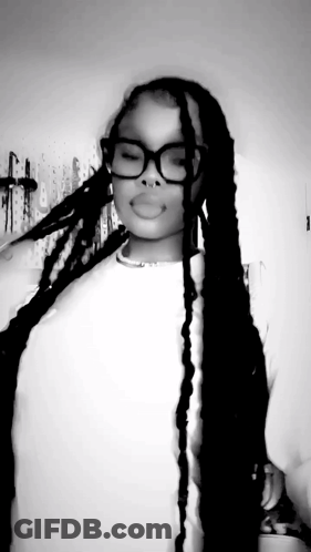 A Black And White Photo Of A Woman With Long Braids Wearing Glasses And A Nose Ring . GIF