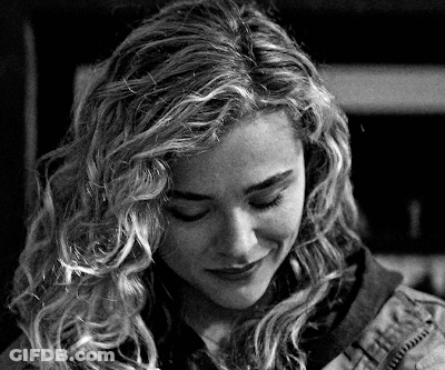 A Black And White Photo Of A Woman With Long Curly Hair GIF