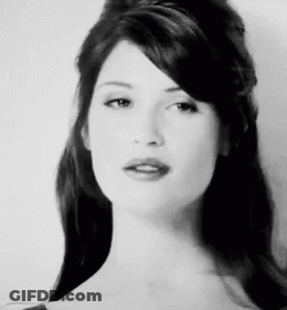 A Black And White Photo Of A Woman With Long Hair And A Fringe . GIF