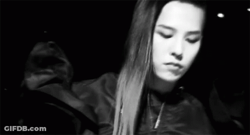 A Black And White Photo Of A Woman With Long Hair In A Jacket . GIF