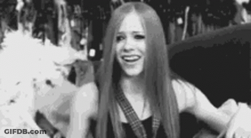 A Black And White Photo Of A Woman With Long Hair Smiling . GIF