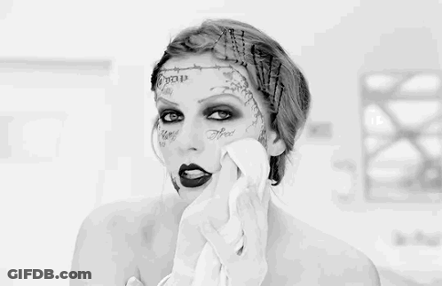 A Black And White Photo Of A Woman With Tattoos On Her Face GIF