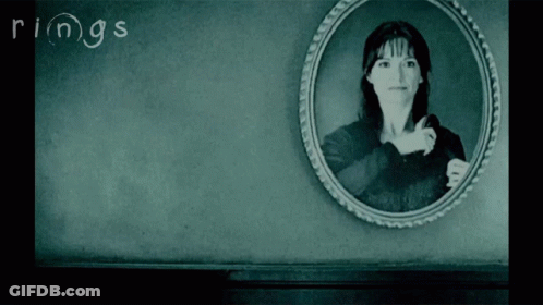 A Black And White Photo Of A Woman With The Word Rings Written On The Wall GIF