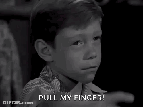 A Black And White Photo Of A Young Boy Pointing With The Words Pull My Finger Below Him GIF