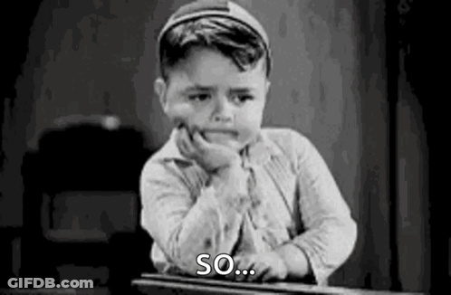 A Black And White Photo Of A Young Boy Sitting At A Desk With His Hand On His Face . GIF