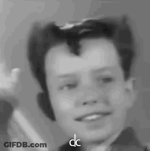 A Black And White Photo Of A Young Boy With The Letters Dc Next To Him GIF