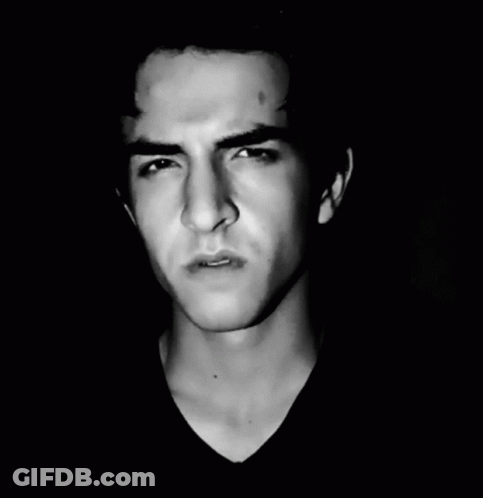 A Black And White Photo Of A Young Man Making A Face GIF