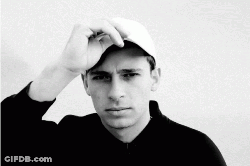 A Black And White Photo Of A Young Man Wearing A Hat GIF