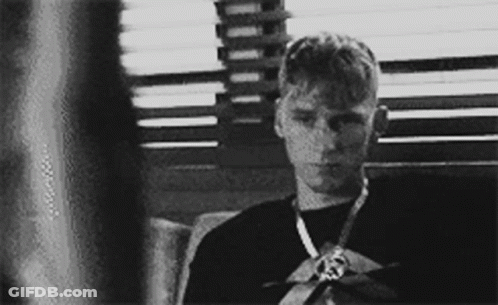 A Black And White Photo Of A Young Man Wearing A Medal GIF