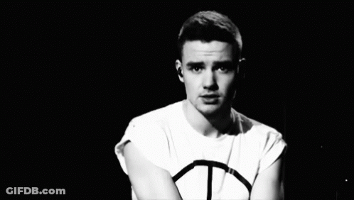 A Black And White Photo Of A Young Man Wearing A Peace Sign Shirt GIF