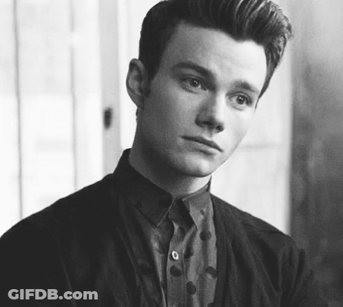 A Black And White Photo Of A Young Man Wearing A Polka Dot Shirt And Jacket . GIF