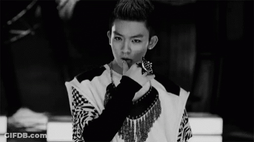 A Black And White Photo Of A Young Man With His Finger On His Lips . GIF