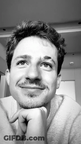 A Black And White Photo Of A Young Man With His Hand On His Chin GIF
