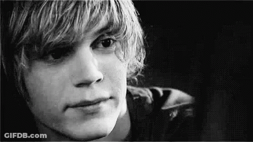 A Black And White Photo Of A Young Man With Long Blonde Hair . GIF