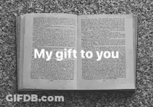 A Black And White Photo Of An Open Book With The Words My Gift To You Written On It . GIF
