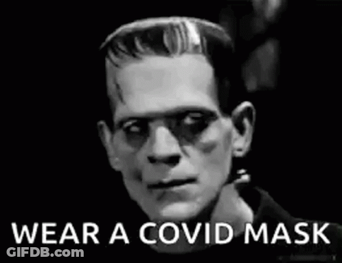 A Black And White Photo Of Frankenstein Wearing A Mask . GIF
