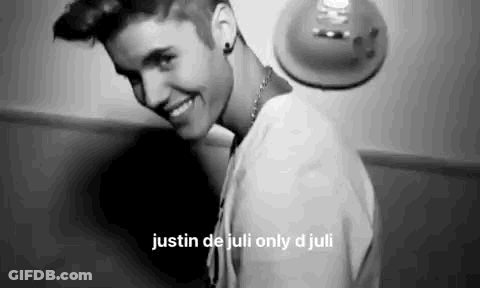 A Black And White Photo Of Justin Bieber Smiling And Looking At The Camera . GIF