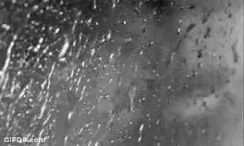 A Black And White Photo Of Rain Drops On A Window GIF