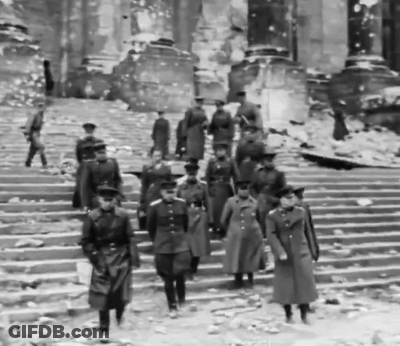 A Black And White Photo Of Soldiers Walking Down A Set Of Stairs GIF