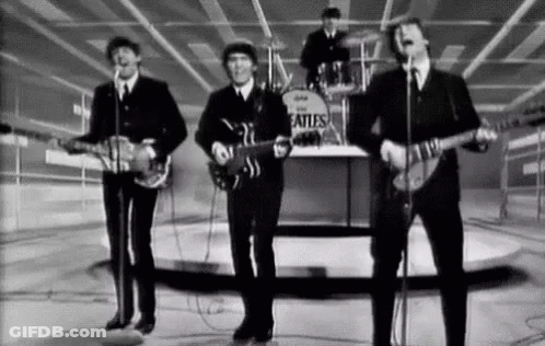 A Black And White Photo Of The Beatles Playing Guitars And Singing Into Microphones . GIF