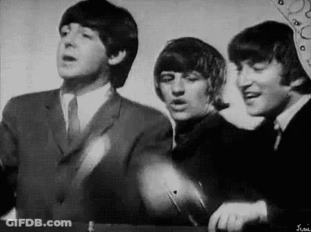 A Black And White Photo Of The Beatles Singing . GIF