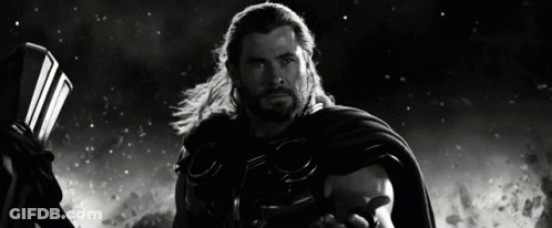 A Black And White Photo Of Thor Holding A Hammer And Cape GIF