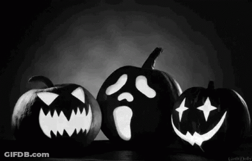 A Black And White Photo Of Three Carved Pumpkins With Faces On Them . GIF
