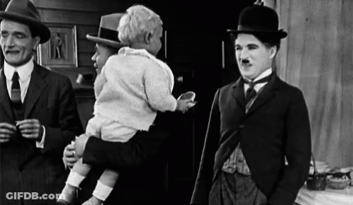 A Black And White Photo Of Three Men Standing Next To Each Other . One Of The Men Is Holding A Baby . GIF