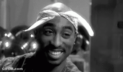 A Black And White Photo Of Tupac Shakur Smiling GIF
