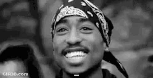 A Black And White Photo Of Tupac Shakur Wearing A Bandana . GIF