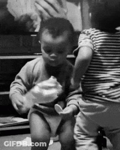 A Black And White Photo Of Two Babies Playing GIF