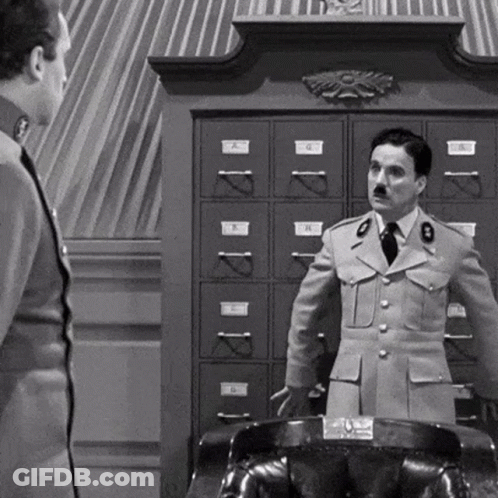 A Black And White Photo Of Two Men In Military Uniforms Standing Next To Each Other In Front Of A Filing Cabinet . GIF
