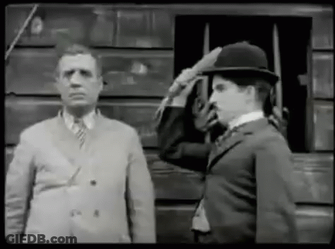 A Black And White Photo Of Two Men Saluting Each Other . GIF