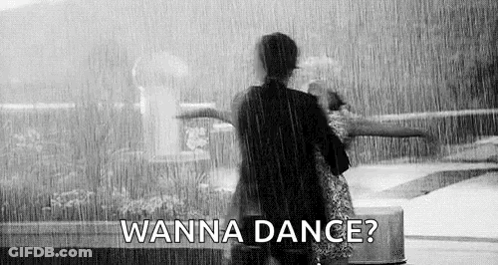 A Black And White Photo Of Two People Dancing In The Rain . GIF