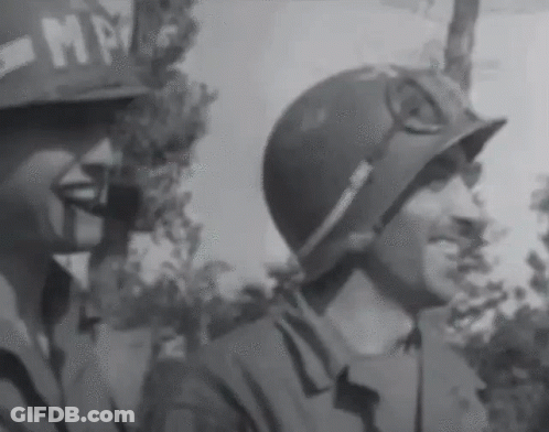 A Black And White Photo Of Two Soldiers With One Wearing A Helmet That Says Mp On It GIF