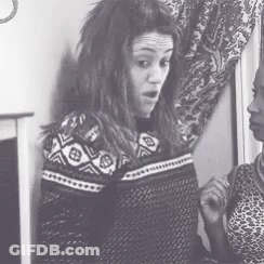 A Black And White Photo Of Two Women Standing Next To Each Other In A Room . GIF