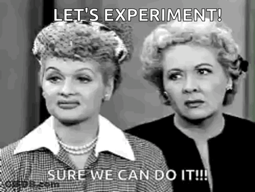 A Black And White Photo Of Two Women Standing Next To Each Other . One Of The Women Is Saying `` Let 'S Experiment ! '' GIF