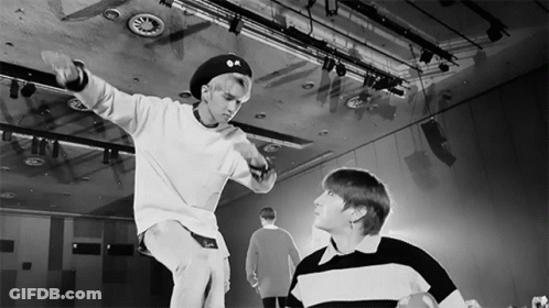 A Black And White Photo Of Two Young Men In A Dance Studio GIF