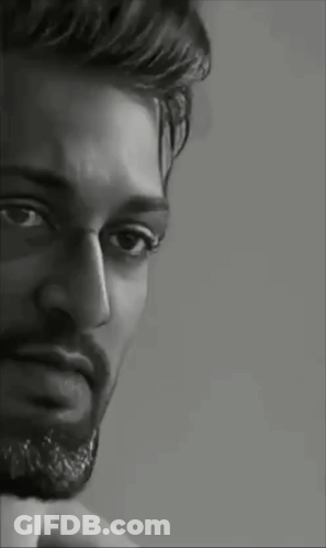 A Black And White Portrait Of A Man With A Beard Looking At The Camera . GIF